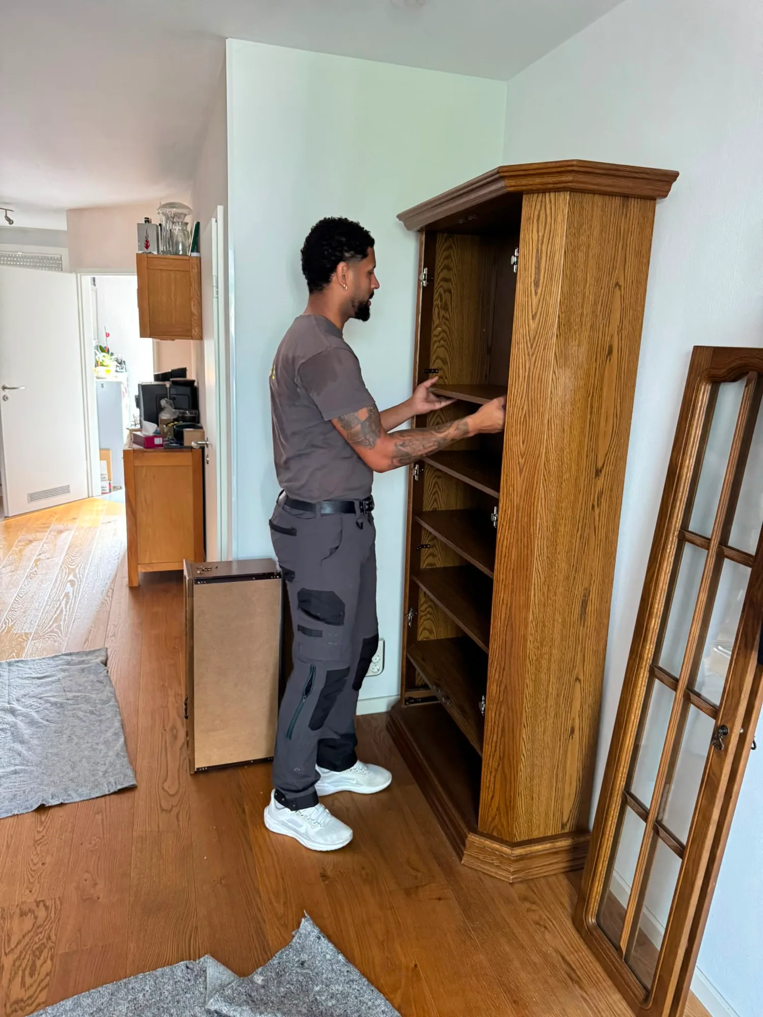 Mitarbeiter von Family Umzüge montiert einen massiven Eichenschrank in einer Wohnung