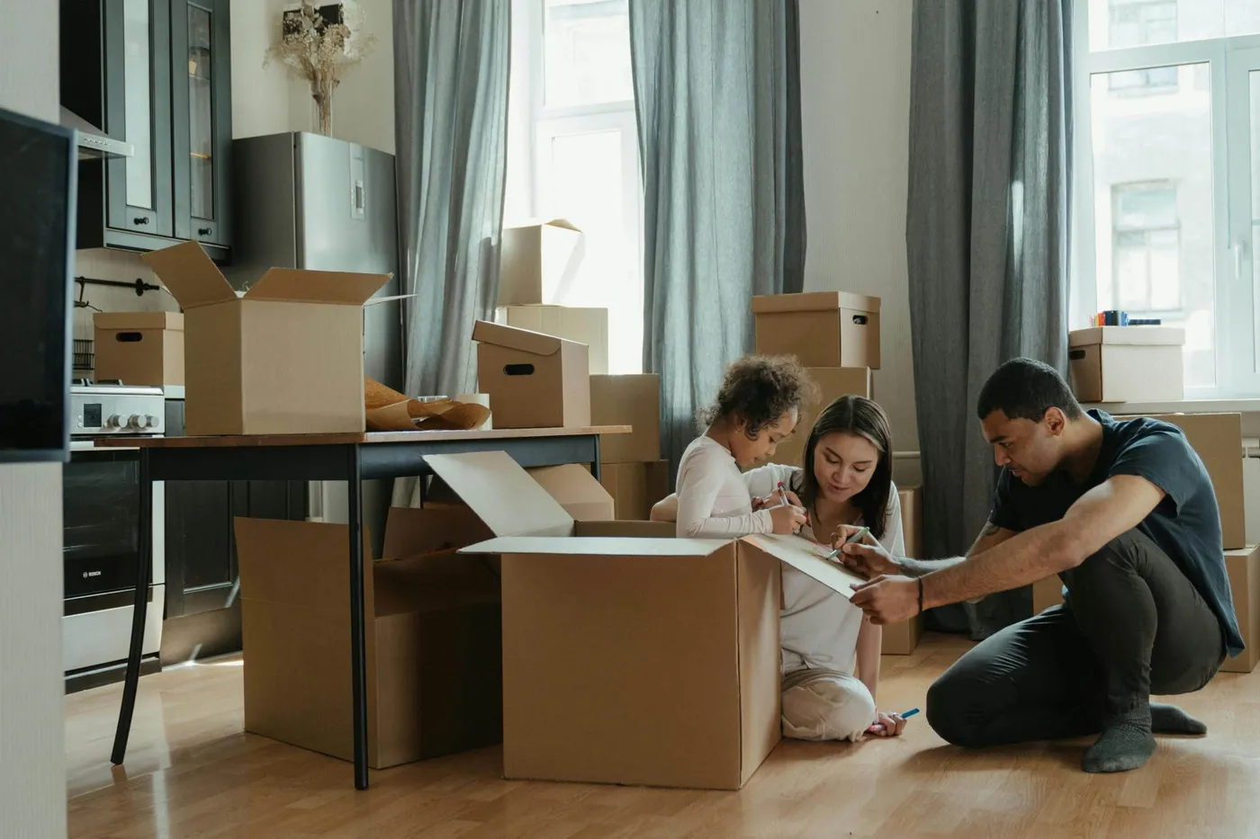 Familie packt in ihrer neuen Wohnung Umzugskartons aus – Rundum-Umzugsservice von Family Umzüge in Frankfurt